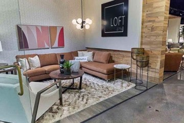 lifestyle photo of a coral L shaped desk coffee table patterned rug and white chair